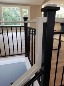 gallery_vertical-spindle-wood-capped-newel-posts-metal-railing-metal-railing-with-wood-graspable-stained-wood-handrail-grand-rapids-mi-prosource-metalworks